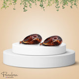 Pair of banana clip on a white pedestal with a beige background and 'Parcelona' branding.