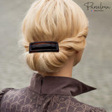 Person with blonde hair styled in an updo wearing a Large Rectangular brown barrette hair clip, with 'Parcelona' branding.