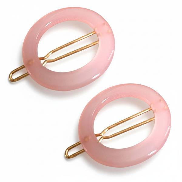 Two pink hair clips with gold metal bars on a white background