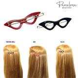 Two cat-eye hair clips, one red and one black, with examples of how they look on hair.