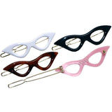 Four cat-eye shaped hair clips in white, black, brown, and pink on a white background.