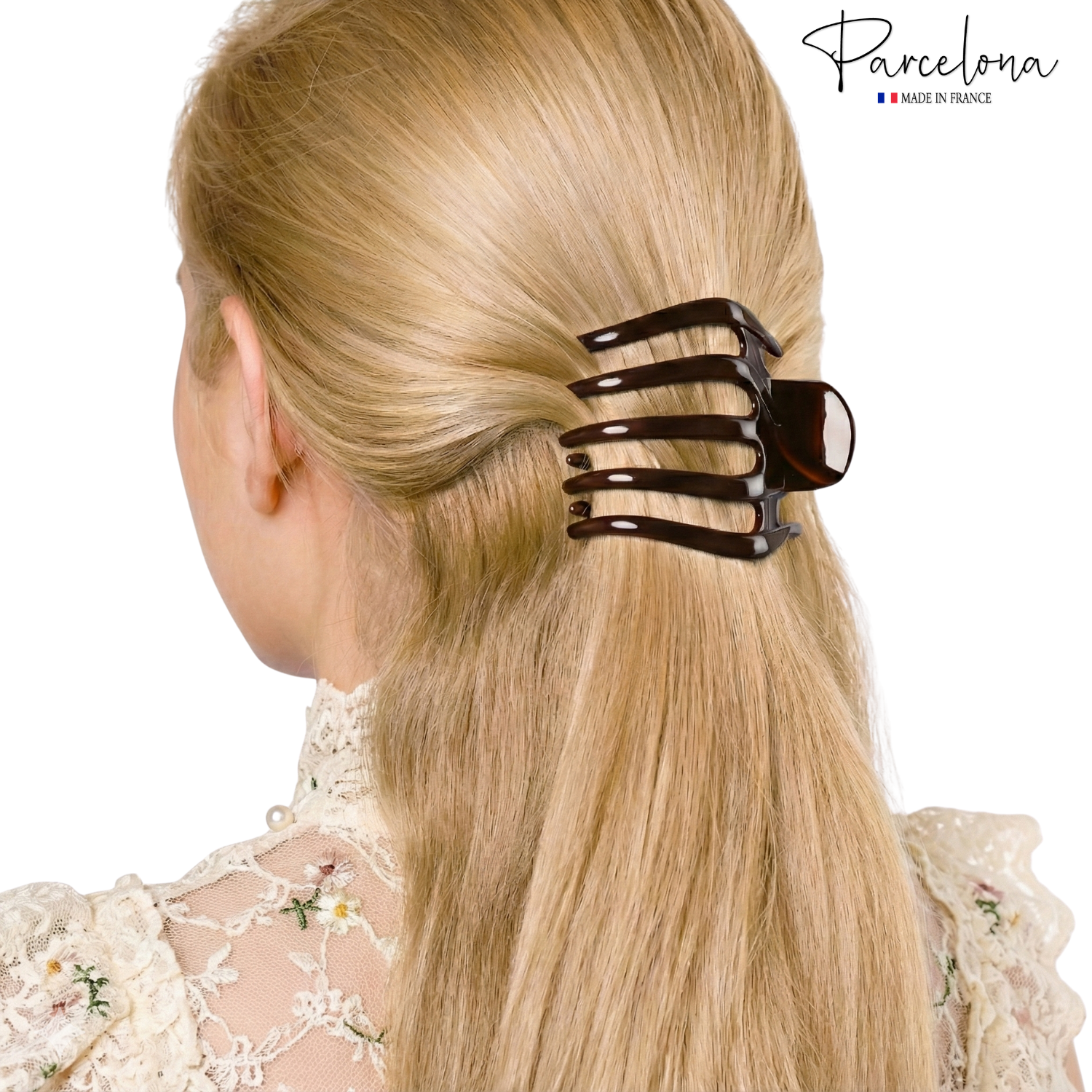 A woman with a hair clip in her blonde hair, wearing a lace top, with the 'Parcelona' brand name.