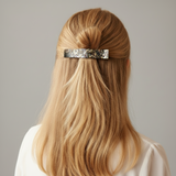 Blonde hair styled with an onyx claw against a neutral background