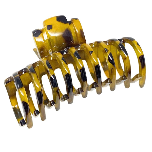 Yellow and black tortoiseshell hair clip on a white background