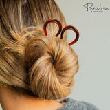 model with a bun holding a hair tie, with 'Parcelona' brand logo.