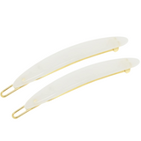 Two white hair clips with gold hardware on a white background