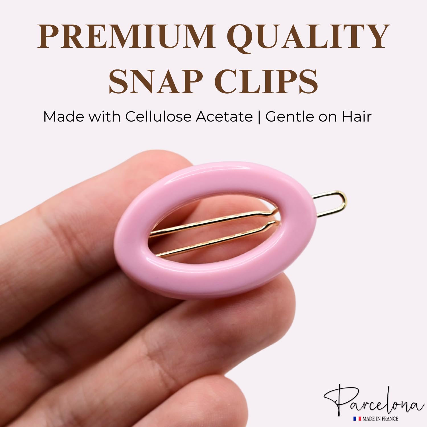 Pink snap clip held in a hand with text about premium quality and Parcelona brand.
