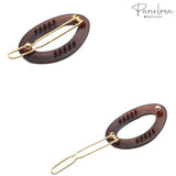 Two hair clips with gold accents on a white background, branded 'Parcelona'.