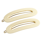 Two Ivory-colored hair clips with gold hardware on a white background