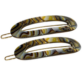 Two onyx hair clips on a white background