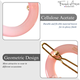 Pink cellulose acetate snap clips with gold accents on a grey background, featuring 'French Amie' branding.