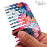 Colorful floral comb held by a hand with 'Parcelona' branding.