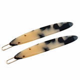 Two white tokyo hair pins on a white background