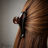 Dolphin hair claw clip securing half-up hairstyle on brunette hair