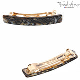 Two hair clips with marbled design and gold accents on a white background, branded 'French Amie'.