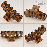 Brown hair clip with 'Parcelona' branding on a light background