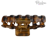 Brown tortoiseshell hair clip with gold accents on a white background, featuring the Parcelona brand.