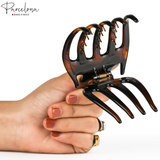 Hand holding Parcelona tortoise shell claw clip showing grip and size reference