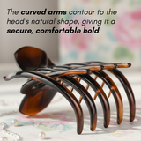 Tortoise shell French hair claw placed on table showing curved arms and comfortable hold design