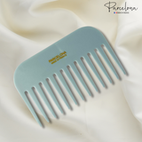 Light blue comb with 'Parcelona' branding on a white fabric background