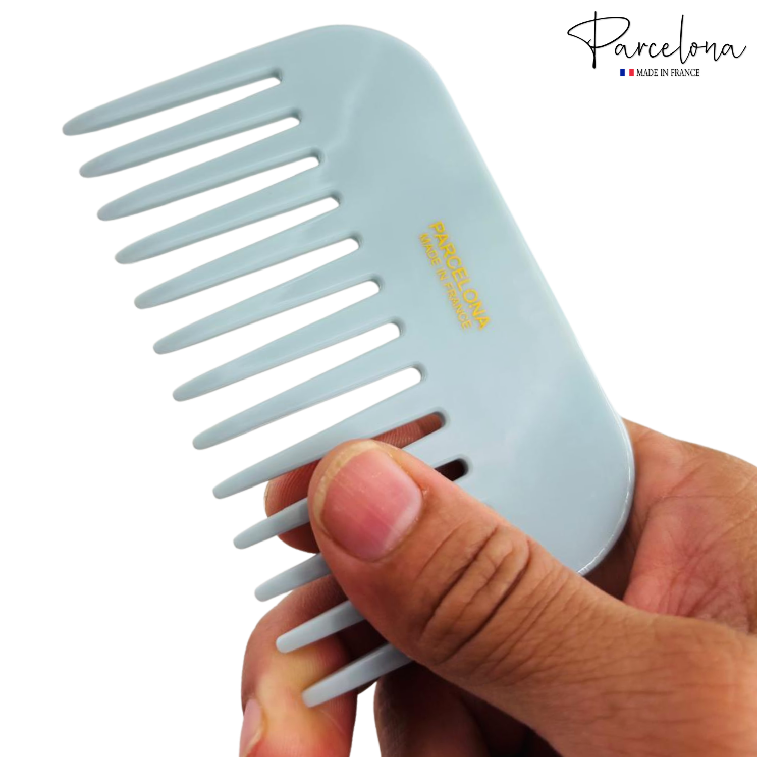 Light blue comb held by a hand with 'Parcelona' branding on a white background