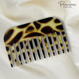 giraffe print comb with 'Parcelona' branding on a white fabric background