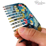 Colorful comb with tropical design held by a hand, brand 'Parcelona' visible