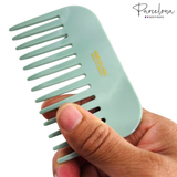 Light blue comb held by a hand with 'Parcelona' branding on a white background