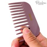 Pink comb held by a hand with 'Parcelona' branding on a white background